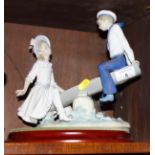 A Lladro porcelain group, children with seesaw, on oval base, 10" high (girl's right thumb broken