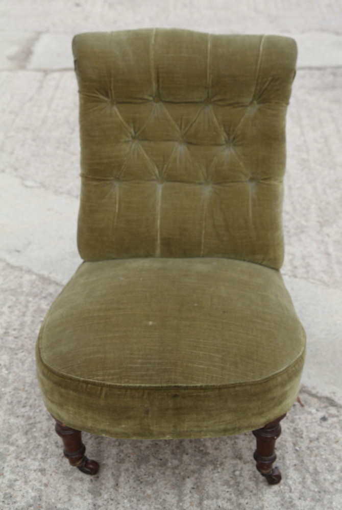 A Victorian mahogany nursing chair, upholstered in a green Dralon, on turned and castored supports