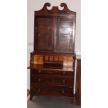 A George III mahogany bookcase with scroll cornice enclosed two beaded glazed doors over fitted