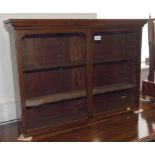 A wall mounted shallow mahogany display case with two glazed doors enclosing two adjustable shelves,