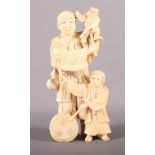 A 19th Century signed Japanese okimono of a figure with a demon puppet and a child drummer, 5" high