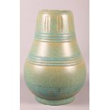 A Susie Cooper green mottled glazed terracotta vase with carved decoration, inscribed to the base