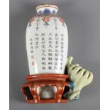 A Chinese porcelain wall pocket, in the form of a vase on a stand, decorated with Chinese script,