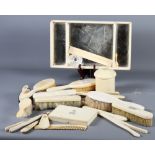 A late 19th Century ivory dressing table set comprising mirror-based tray, trinket box, brushes,