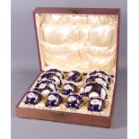 A cased set of six Coalport coffee cans and saucers decorated in dark blue and gilt with floral