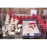 A 19th Century Cantonese red and white ivory chess set with pedestal bases carved puzzle balls and a