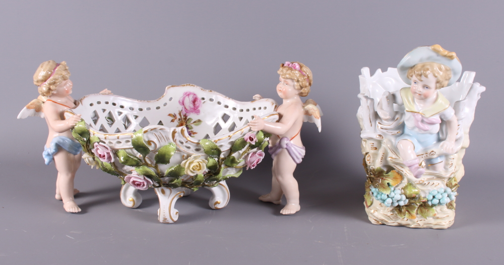 A mid 20th Century Continental porcelain table centre, basket with cherub supports and floral relief