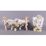 A mid 20th Century Continental porcelain table centre, basket with cherub supports and floral relief