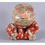 A Japanese polychrome enamelled lamp base, formed as a Dog of Fo balancing a ball, 8 1/2" high