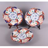 A set of three Japanese Imari porcelain dishes with lobed edges, painted panels of animals and