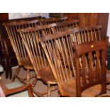 A set of six spindle back dining chairs with carved top rails, saddle-shaped wooden seats, on turned