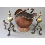 A pair of iron fire iron rests with decorative brass finals and a copper coal scuttle
