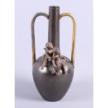 An Art Deco style bronzed two-handled bottle-shaped vase decorated two cherubs, 10" high