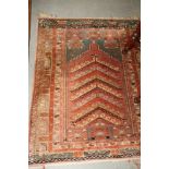 A Persian prayer rug decorated stepped mihrab on a red ground with five border stripes