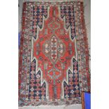 A Kazak rug decorated central ivory medallion on a red ground with three border stripes, 48" x 30"