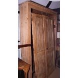 A pine cupboard enclosed two boarded doors, 54" x 84" high