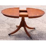 A reproduction yew circular single pedestal dining table with centre leaf, 44" dia