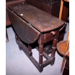 An 18th century oval oak drop leaf dining table, fitted end drawer, 36" long