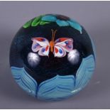 A glass paperweight decorated central butterfly, flowers and leaves, base engraved "EL53M 1978