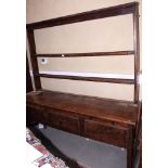 An 18th century oak dresser with open back, fitted two shelves over base fitted three drawers, on