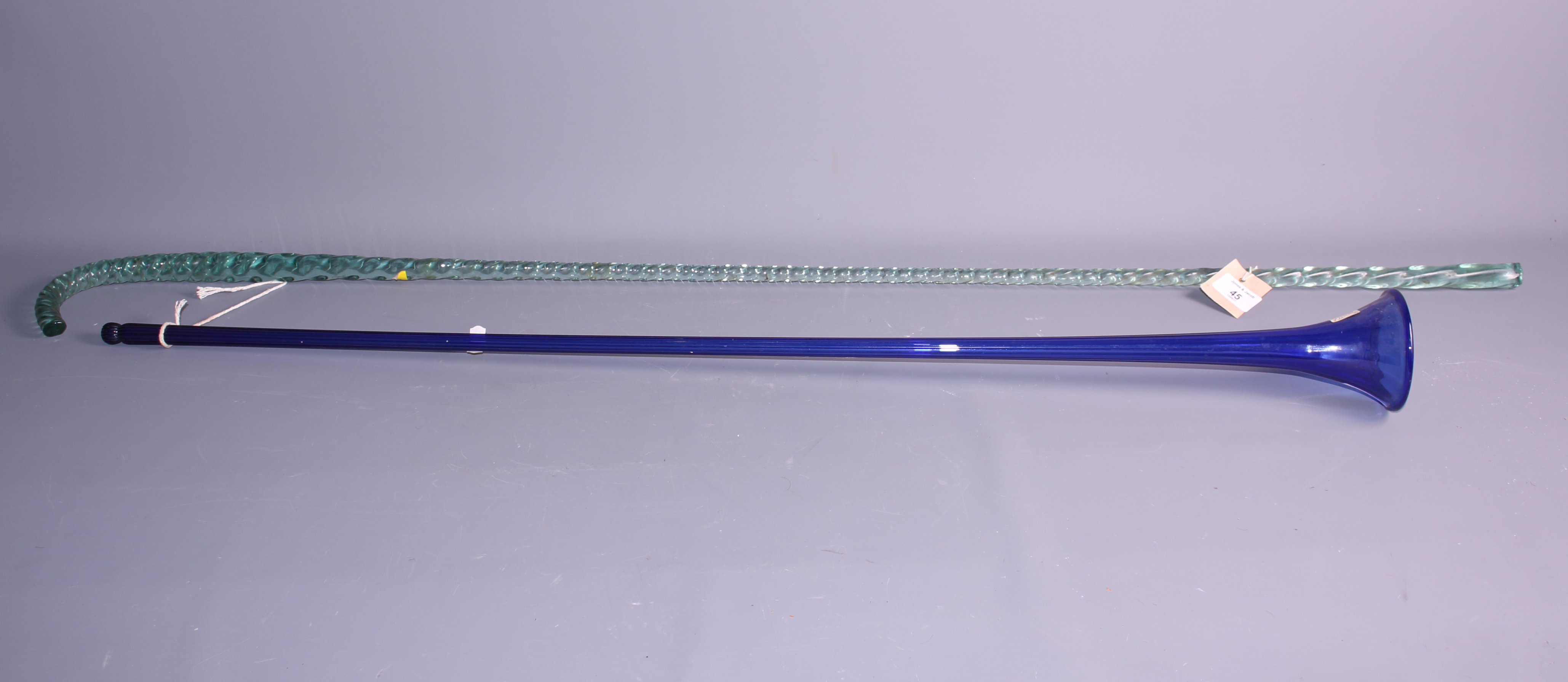 A reeded glass coaching horn, 39" long, and a twisted green glass walking stick, 48" long