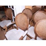 A set of seven Louis XVI design beech framed dining chairs with oval cane double backs and seats, on