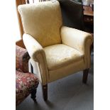 An early 20th century armchair, upholstered in a gold brocade, on square supports