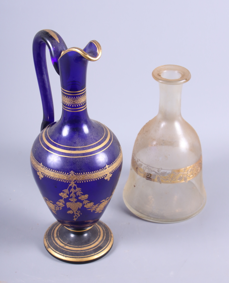 A 19th century blue glass ewer with tooled gilt decoration, 12" high, and a clear bell-shaped