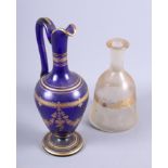 A 19th century blue glass ewer with tooled gilt decoration, 12" high, and a clear bell-shaped