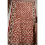 A Persian design rug decorated Herati pattern on a red ground with border, 64" x 33" approx, and