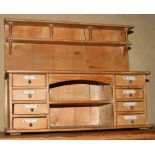 A doll's pine kitchen dresser, the base fitted eight drawers and central open shelves, 16" wide, and