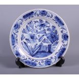 An 18th century blue and white Delft plate with tree and fence decoration, 9" dia (hair crack)