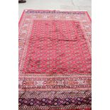 A Bokhara design silky pile rug on a red ground, 110" x 79" approx