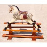 A child's dapple grey wooden rocking horse, on safety stand