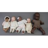 Two Armand Marseille bisque headed dolls wearing white smocks and three brown coloured dolls