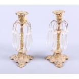 A pair of 19th century gilt metal candlesticks, hung spear point glass drops on arching arms, on
