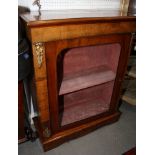 A late Victorian pedestal display cabinet enclosed by door inset arch glazed panel and gilt metal