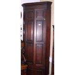 A Georgian oak two-stage standing corner cabinet enclosed by plain panelled doors, 23" wide x 80"