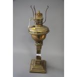 A brass oil lamp (now converted to electricity), on square base, 24" high, two other oil lamps and a