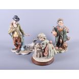 Three Capodimonte figures, a man with a dog, a tramp and a grandmother putting children to bed