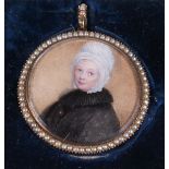 An early 19th century portrait miniature of a woman, in seed pearl inset frame, inscribed verso "
