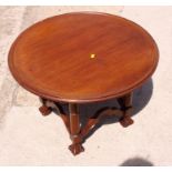 A circular mahogany coffee table with dished top, on four turned supports with Braganza feet, 27"