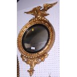 A Regency style giltwood framed convex wall mirror with eagle surmount, 31" high (damages)