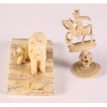 Two carved ivory elephants, on elephant tooth base, and a carved ivory puzzle ball chess piece