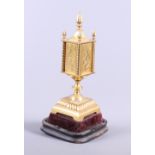 A gilt metal tabernacle, on velvet and ebonised base, 12" high