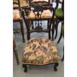 A late Victorian dark stained salon nursing chair with carved and pierced central splat and