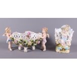 A mid 20th century Continental porcelain table centre, basket with cherub supports and floral relief