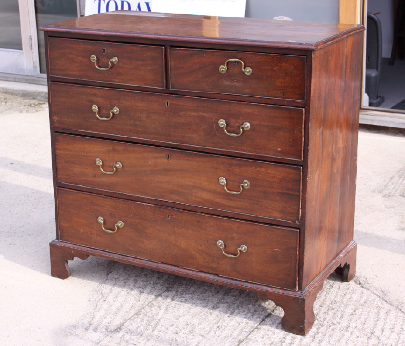 A Georgian mahogany chest of two short and three long drawers with brass loop handles, on bracket