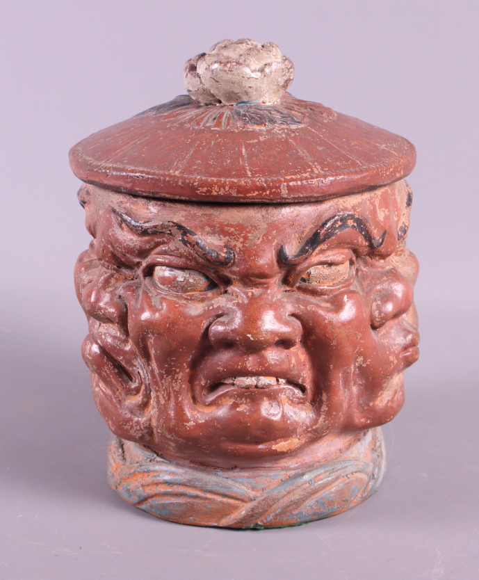 A mid 19th century painted terracotta tobacco jar with demon faces, 6" high