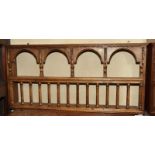 A carved oak wall shelf with arcaded top and spindles, 42" wide